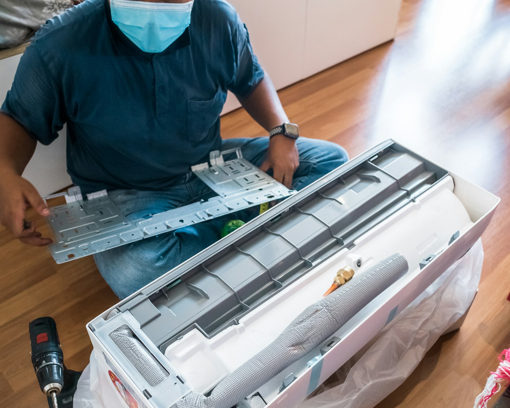 Technician assembling air conditioner on the floor.